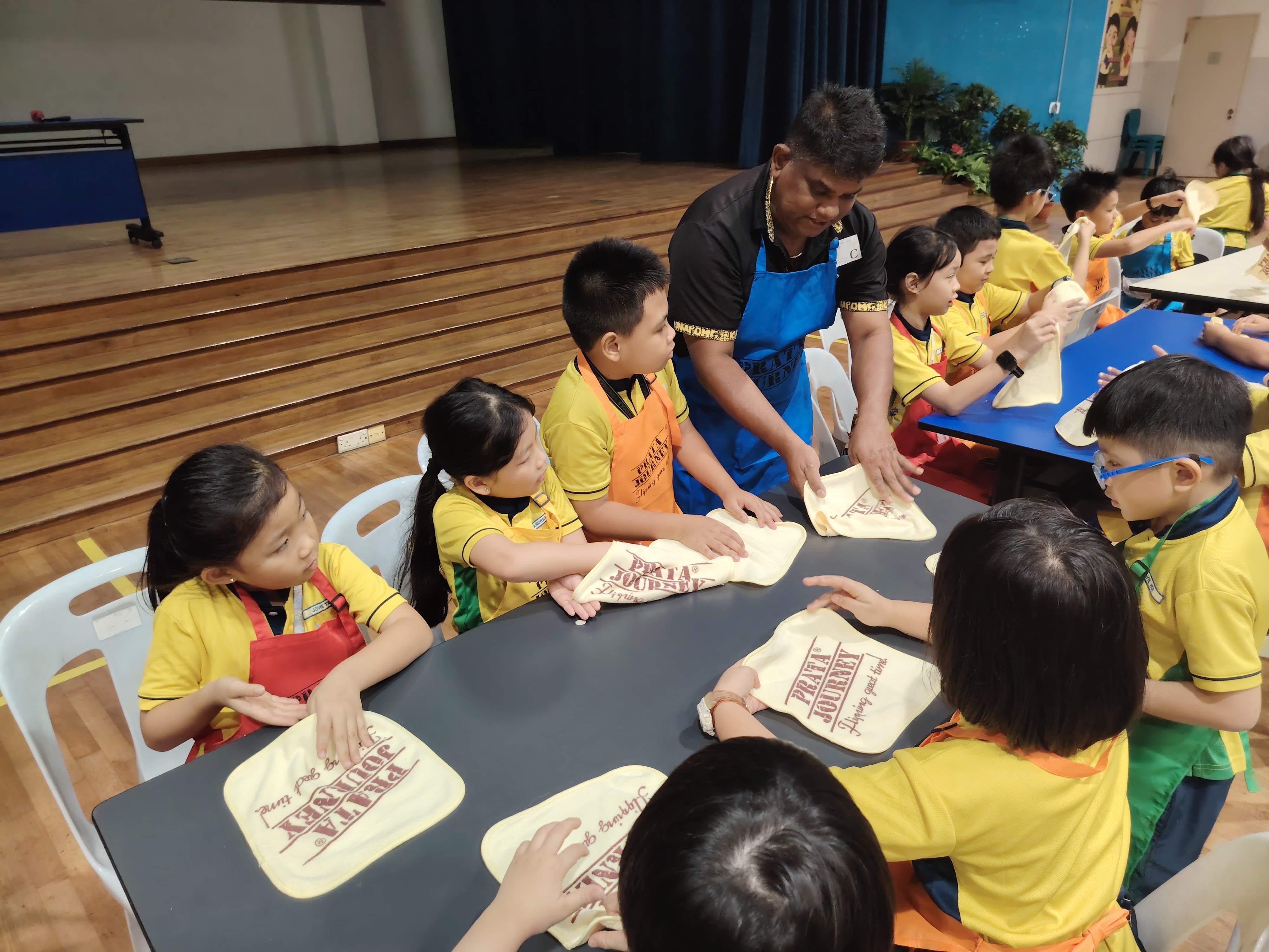 Enthusiastic students learning how to flip roti prata using towels as basic training